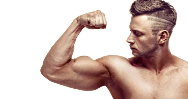 Svalnatý mimořádně vysoké úrovni pohledný muž pózuje na bílém pozadí. ukazuje jeho biceps. — Stock fotografie