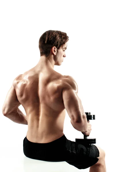 Schöne muskulöse männliche Modell sitzt auf einem Würfel und posiert vor weißem Hintergrund. — Stockfoto
