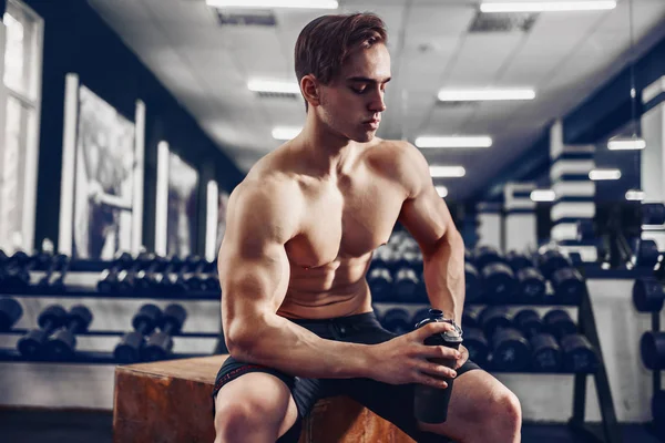 Sehr kraftvoller, athletischer Typ, der sich nach dem Workout im Fitnessstudio entspannt — Stockfoto