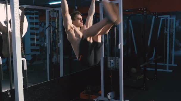 Hombre joven haciendo ejercicios abdominales en el gimnasio — Vídeos de Stock