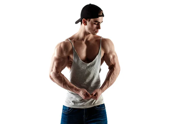 Musculoso hombre guapo de súper alto nivel en gorra de béisbol y camiseta sin mangas posando sobre fondo blanco —  Fotos de Stock