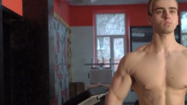 Spor salonunda egzersiz yapan genç atletik erkek. Sığ derinlik-in tarla. Omuz yükseltmek plaka ile