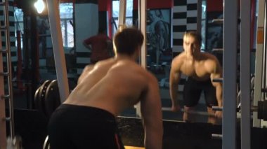 Spor salonunda egzersiz yapan genç atletik erkek. Sığ derinlik-in tarla. Spor salonu makinede geri çekme