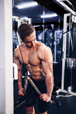 Yakışıklı kaslı Fitness vücut geliştirmeci Triceps için ağır egzersiz yaparak
