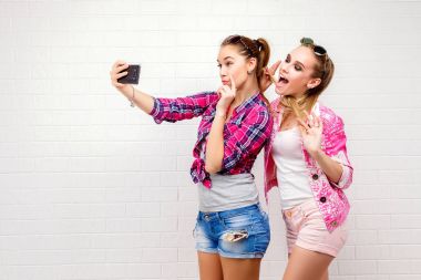 İki arkadaş poz moda portre. Modern lifestyle.two şık seksi hipster kızlar en iyi arkadaşlar parti için hazır. İki genç kız birlikte ayakta ve having fun arkadaşlar.