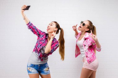 İki arkadaş poz moda portre. Modern lifestyle.two şık seksi hipster kızlar en iyi arkadaşlar parti için hazır. İki genç kız birlikte ayakta ve having fun arkadaşlar.