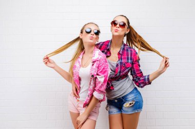 İki arkadaş poz moda portre. Modern lifestyle.two şık seksi hipster kızlar en iyi arkadaşlar parti için hazır. İki genç kız birlikte ayakta ve having fun arkadaşlar.