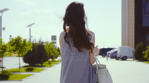 Stylische Dame mit Handtasche nähert sich Businesszentrum. — Stockvideo
