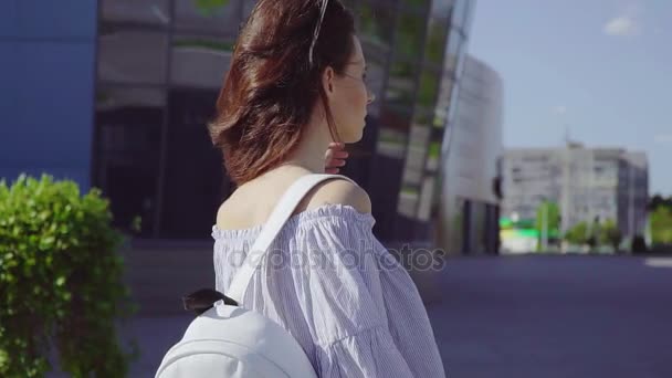 Молодая красивая женщина с кудрявыми волосами и рюкзаком в современном торговом центре . — стоковое видео