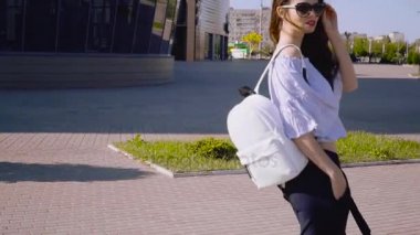 Genç güzel kadın kıvırcık saçlı ve sırt çantası Modern alışveriş merkezi.