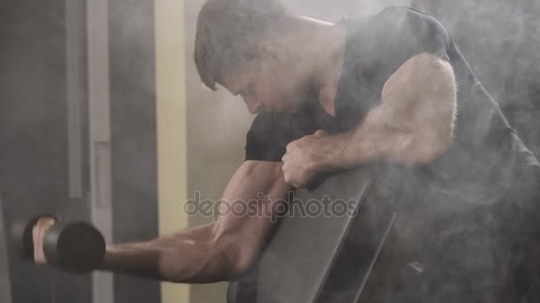 Jeune musclé musclé bodybuilder exercice biceps avec haltères à la salle de gym . — Video