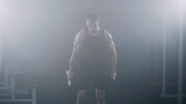 Strong Młodzi mięśni mężczyzna kulturysta wykonując Biceps z hantlami w siłowni. — Wideo stockowe