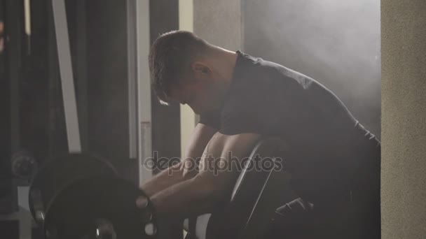 Jeune musclé musclé bodybuilder exercice biceps avec grand haltère à la salle de gym . — Video