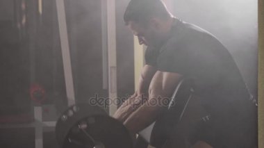 Dumbbell ile pazı egzersizleri yaparken kas vücut geliştirmeci adam