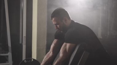 Dumbbell ile pazı egzersizleri yaparken kas vücut geliştirmeci adam