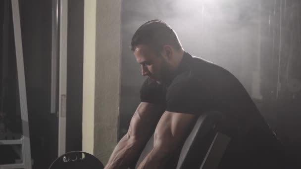 Muscular fisiculturista cara fazendo exercícios em bíceps com halteres — Vídeo de Stock