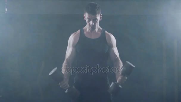 Stark ung muskulös manliga kroppsbyggare tränar Biceps med hantlar på gymmet. — Stockvideo