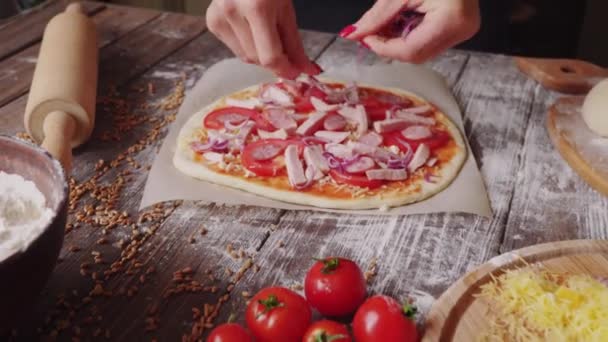 Frau legt beim Pizzabacken in der Küche Zutaten auf den Teig — Stockvideo