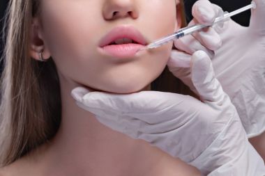 Beyaz kadın portresi kozmetik enjeksiyon yaptırıyor.