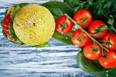 Burger yeşil topuz ve taze sebze ahşap arka plan üzerinde beyaz