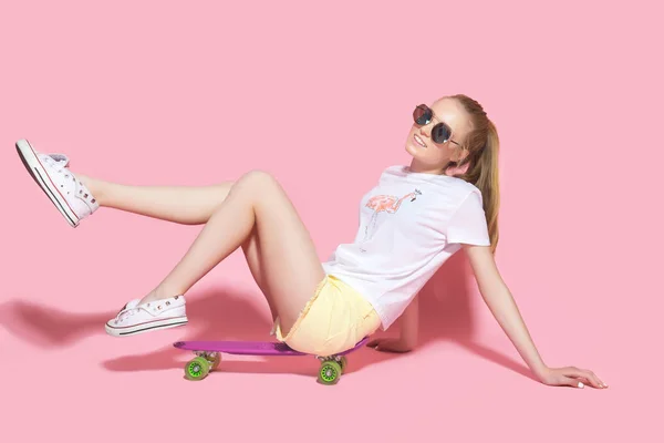 Lachende meisje zit op skateboard — Stockfoto
