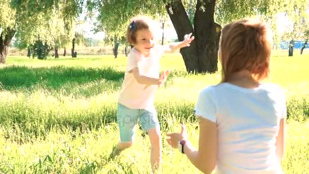 딸은 어머니 팔에 몰리게 하 고 그녀에 게 큰 포옹을 제공. 외부 공원에서. — 비디오