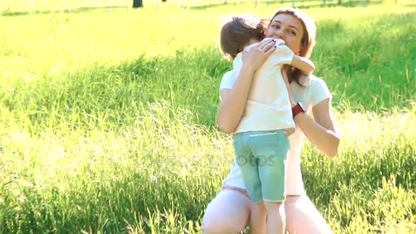 Daughter rushes into mothers arms and gives her a big hug. Outside in the park. — Stock Video