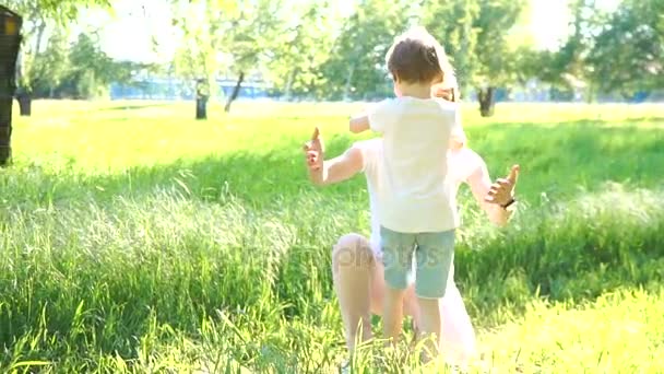 Daughter rushes into mothers arms and gives her a big hug. Outside in the park. — Stock Video
