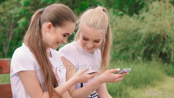 Feliz namoradas com smartphone no parque — Vídeo de Stock