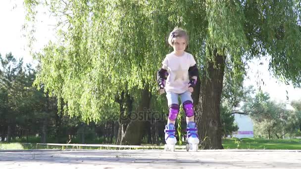 Маленька дівчинка вчиться кататися на роликах — стокове відео