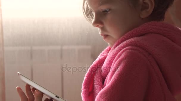 小可爱的小女孩看着平板电脑 — 图库视频影像