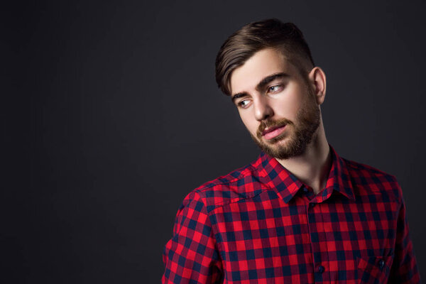 Портрет стильного молодого человека, смотрящего в сторону
