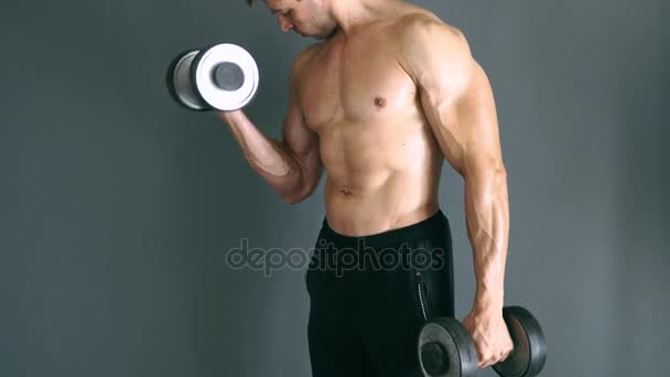 Culturistas en topless concentrados realizando ejercicio de bíceps con pesas . — Vídeo de stock