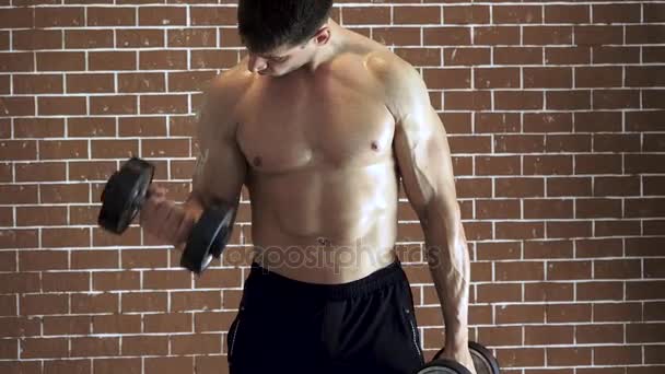 Сильний чоловік робить вправи з гантелями — стокове відео