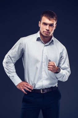 Moda genç ciddi adama sökülen gömlekli olanlar bir yumruk ve kameraya bakarak el clenches