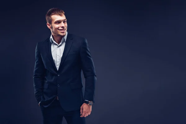 Fashion young businessman black suit on dark background — Zdjęcie stockowe