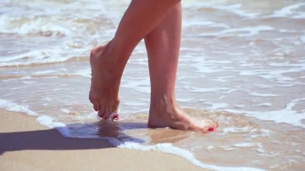 Mujeres piernas en la playa de arena y el mar — Vídeo de stock