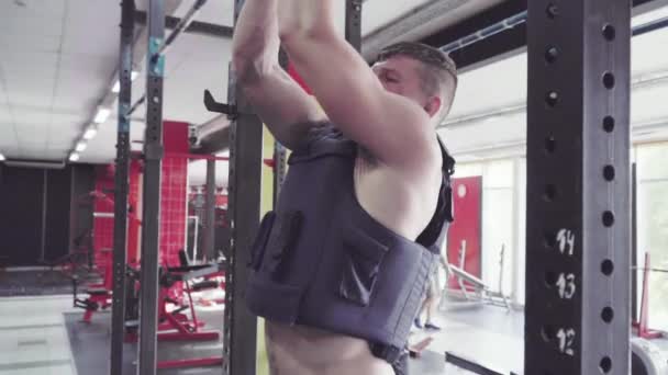 一个年轻人做拉 ups 在健身房里 — 图库视频影像