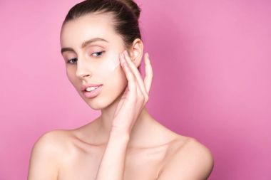 Doğal makyaj uygulayarak güzel model bir kadın yüzüne krem portresi.