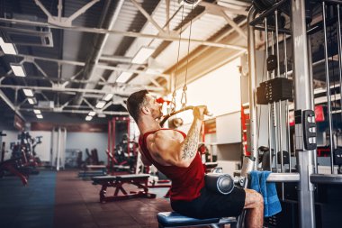 Arka üstünde makine için ağır egzersiz yaparak güçlü vücut geliştirmeci