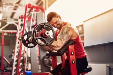 Adam vücut geliştirmeci bir spor salonunda bir halter egzersiz kümesi yapıyor. Gerçek zamanlı vurdu