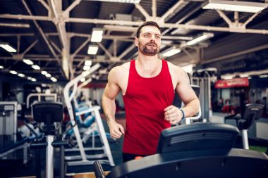 Kas koşu bandı üzerinde çalışan adam.