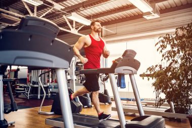 Kas koşu bandı üzerinde çalışan adam.