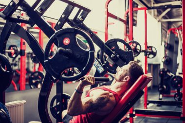 Simülatörde omuzlar için bir egzersiz yapan erkek