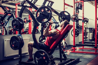 Simülatörde omuzlar için bir egzersiz yapan erkek