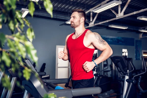 Kas koşu bandı üzerinde çalışan adam.