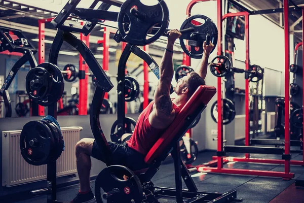 Simülatörde omuzlar için bir egzersiz yapan erkek