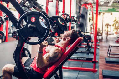 Simülatörde omuzlar için bir egzersiz yapan erkek