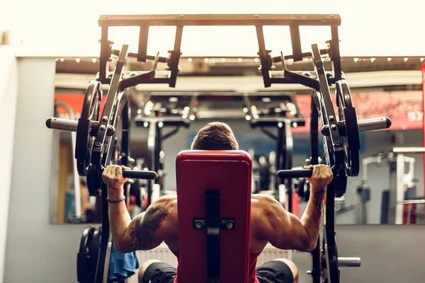 Simülatörde omuzlar için bir egzersiz yapan erkek