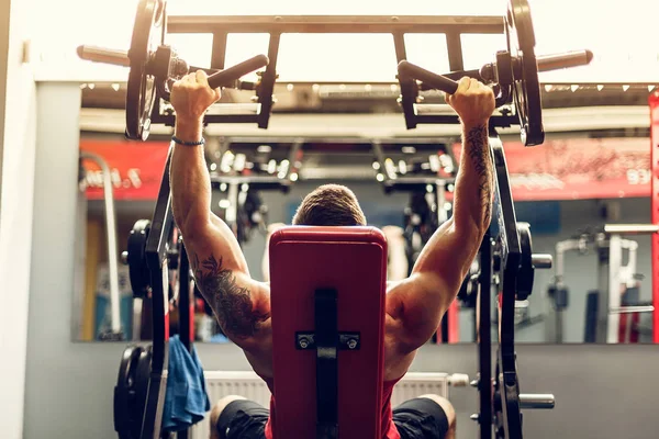 Simülatörde omuzlar için bir egzersiz yapan erkek